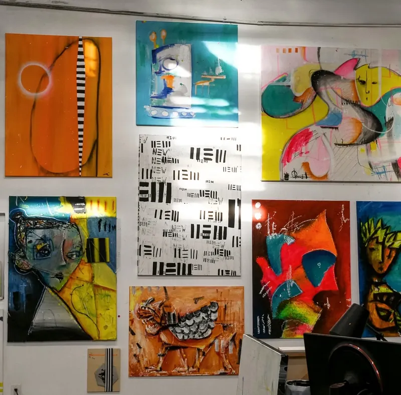 Paintings by Joe Taveras arranged throughout his Boston warehouse studio in 2023.